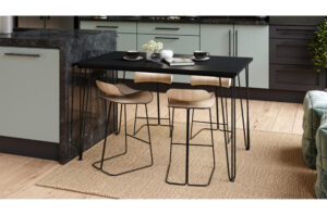 Juodas stalas Hairpin S-120 su metalinėmis kojomis moderniame interjere prie sienos.